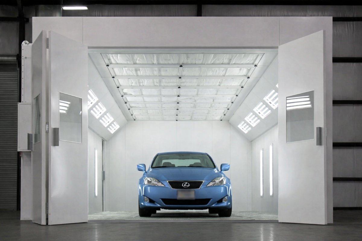 Vehicle inside a professional automotive paint spray booth during refinishing