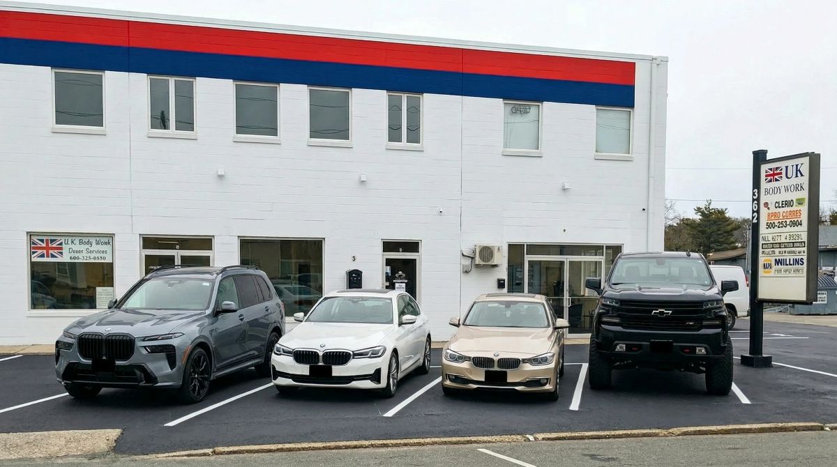 UK Body Work auto body repair shop exterior in Hyannis Massachusetts with customer vehicles parked in front