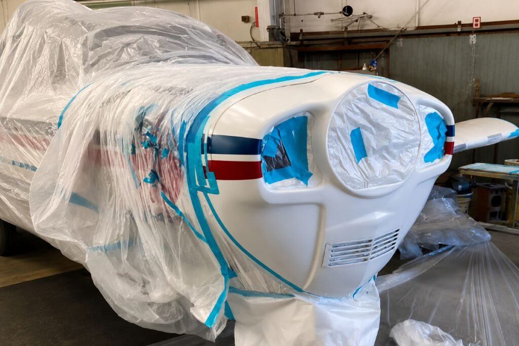 Aircraft nose section professionally masked for refinishing during a specialty aviation repair project at UK Body Work in Hyannis, Massachusetts.