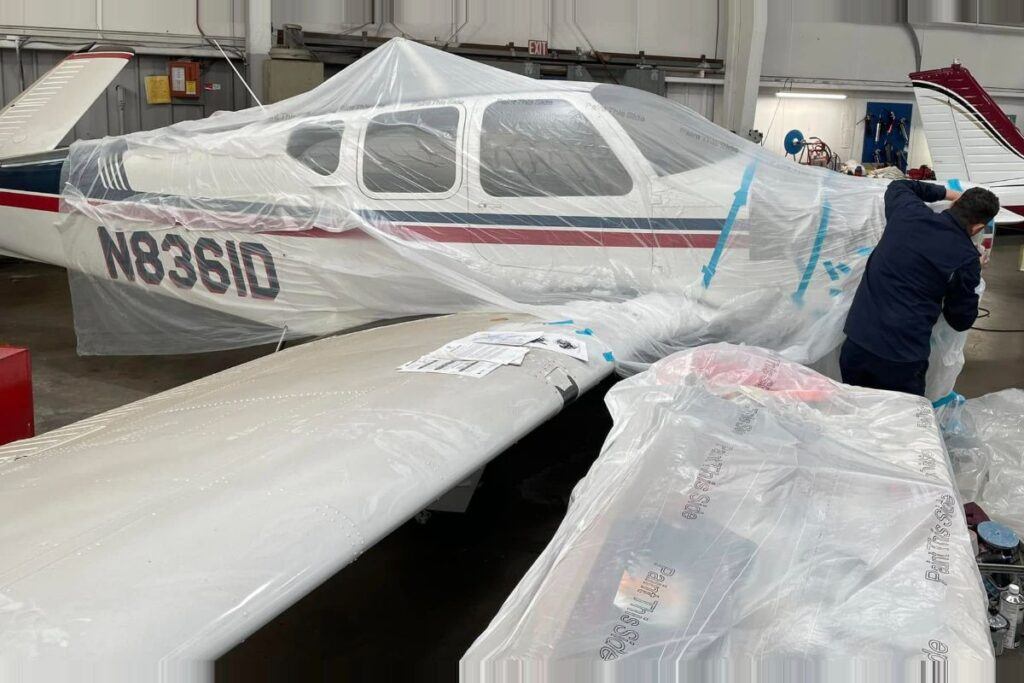 Aircraft masked and prepared for professional paint refinishing at UK Body Work in Hyannis, Massachusetts during a specialty aviation repair project.